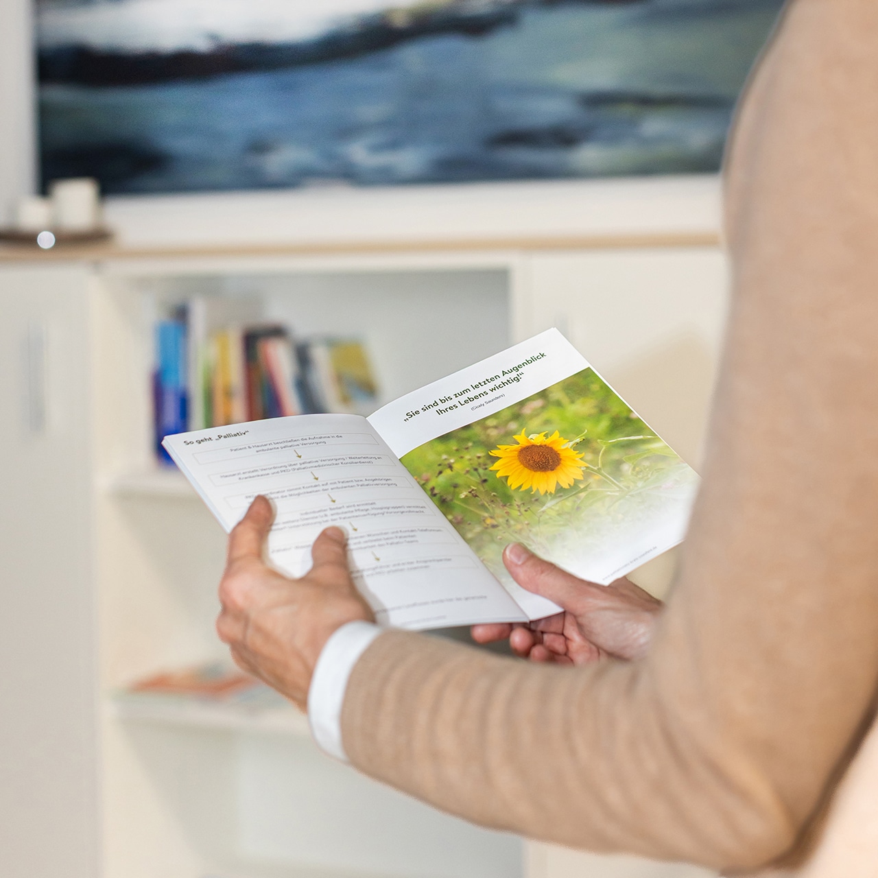 Eine Person hält eine aufgeschlagene Informationsbroschüre zur Palliativversorgung in Händen