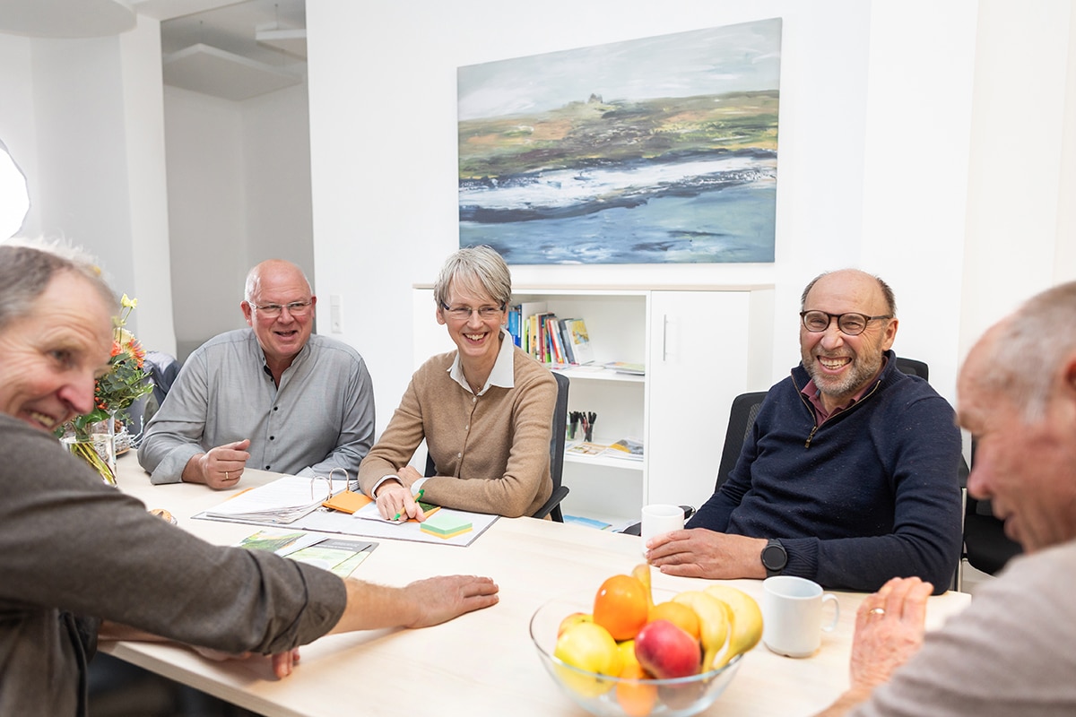 Teamgespräch des Palliativdienstes im Kreis Coesfeld an einem Tisch mit Blumen und Snacks
